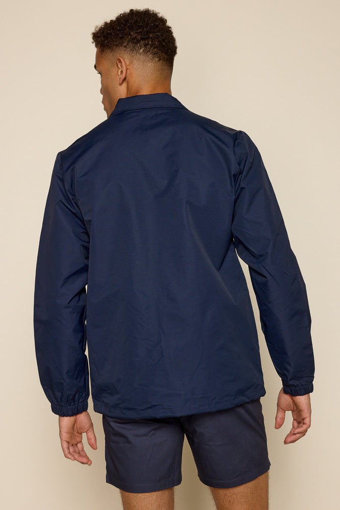 Back view of male model wearing navy coach water resistant jacket