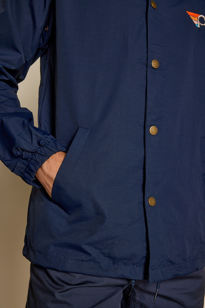 Close up photo of the navy jacket, shows details of the bronze snap on buttons and the right side of pocket